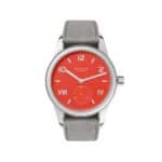 Bold coral-red dial watch by NOMOS Glashütte, featuring sleek design and luxury leather strap.