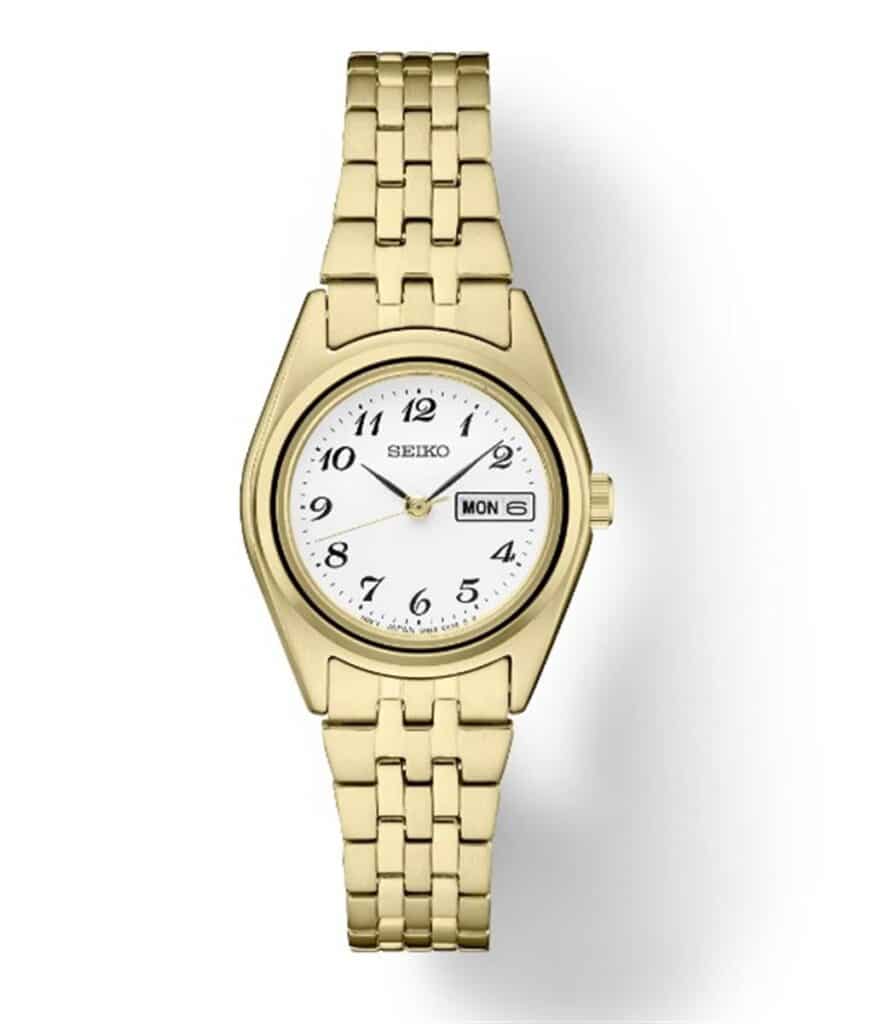 Elegant gold Seiko watch with a white dial, featuring day and date display.