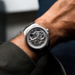 Elegant ORIS watch with skeleton design on wrist, showcasing luxury and precision craftsmanship.