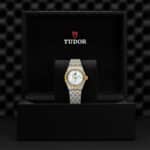 Tudor watch in luxury display box, showcasing elegant silver and gold design and craftsmanship.