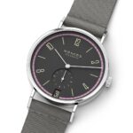 Sleek NOMOS Glashütte watch featuring a gray dial, pink bezel, and textile strap.
