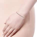 Elegant gold bracelet with shimmering stones, showcased on a relaxed hand against a soft background.