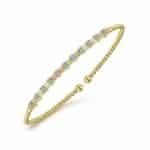 Elegant gold bangle adorned with sparkling stones, perfect for casual or formal occasions.