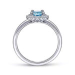 Elegant silver ring with a vibrant blue oval gem and sparkling white halo stones.