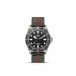 Tudor dive watch with stainless steel case, black dial, and stylish olive green nylon strap.