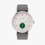 Minimalist NOMOS Glashütte watch features red numerals, green sub-dial, and gray fabric strap.