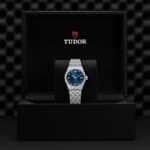 Tudor watch in elegant packaging featuring a striking blue dial and luxurious metal bracelet.