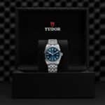 Elegant stainless steel watch with blue dial showcased in luxurious display box.