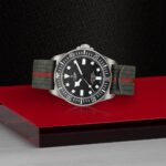 Tudor luxury watch with stainless steel case and unique green and red fabric strap.