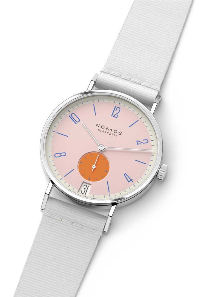 NOMOS Glashütte modern wristwatch with minimalist design, pink dial, and chic white strap.
