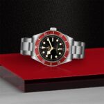 Stunning Tudor diving watch with red bezel on a sleek surface, perfect for adventurers.