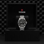 Luxury Tudor watch displayed in elegant black box with sporty design and stainless steel bracelet.