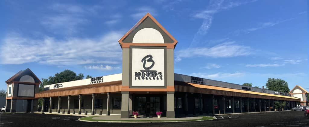 Modern retail building with Brinker’s Jewelers tower and vibrant storefronts in a thriving plaza.