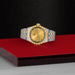 Elegant gold and silver wristwatch on a vibrant red background, showcasing luxury and style.