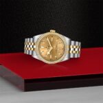 Luxurious gold and diamond watch on textured black background, showcasing exquisite craftsmanship and elegance.