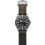 Tudor divers watch with stainless steel case, black dial, and olive green textile strap.