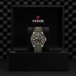 Tudor watch in luxurious presentation box with green strap, showcasing elegance and functionality.