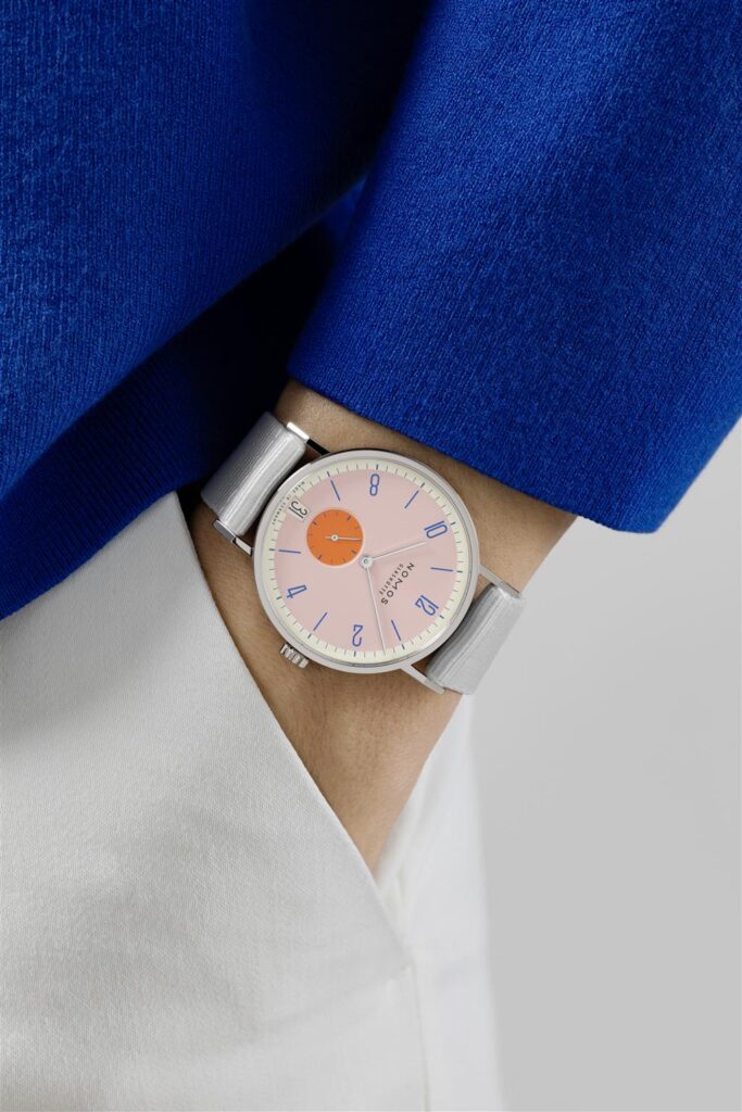 Stylish pink dial watch paired with chic outfit, showcasing modern fashion and elegance.