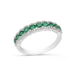 Elegant emerald and white metal ring with intricate design and sparkling gemstone accents.