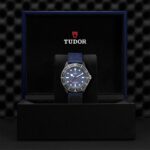 Tudor watch in luxury presentation box showcases elegant design and craftsmanship with deep blue dial.