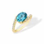 Elegant gold ring with vibrant blue oval gemstone and sparkling diamonds for luxurious style.