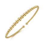Gold cuff bracelet with spherical beads, perfect for casual or formal occasions.