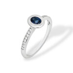 Elegant blue sapphire ring with diamond accents in polished white metal band.