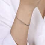 Sleek silver bracelet on a wrist, showcasing minimalist elegance and refined fashion style.