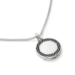 Stylish silver pendant with decorative black pattern on a delicate chain, perfect for any outfit.