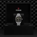 Luxurious Tudor watch in a stylish box, showcasing elegance and craftsmanship with gold accents.