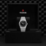 Elegant Tudor watch in a luxurious presentation box, featuring a black dial and stainless steel bracelet.