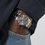 Sleek modern watch on a wrist, blending style with a casual formal look.