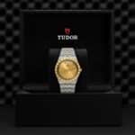 Luxurious Tudor watch displayed in elegant black box with gold dial and two-tone design.