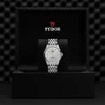 Elegant Tudor wristwatch displayed in luxurious black box, showcasing its exquisite craftsmanship and design.