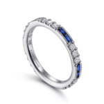 Elegant white gold ring adorned with diamonds and blue sapphires, showcasing exquisite craftsmanship.
