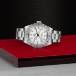 Sleek Tudor wristwatch with stainless steel design, white dial, and dual-time functionality.