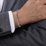 Stylish silver bracelet on a formal gray suit, showcasing sophistication and attention to detail.