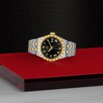 Elegant luxury watch with gold bezel, black dial, and two-tone bracelet design.
