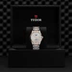 Tudor watch in luxurious presentation box, featuring stainless steel and rose gold design.