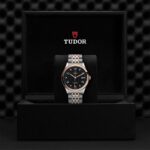 Elegant Tudor watch showcased in luxurious box with plush interior and stylish two-tone bracelet.