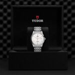 Elegant Tudor watch in luxury display box, showcasing stainless steel design and classic craftsmanship.