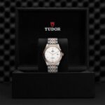 Luxurious Tudor watch in elegant black box, showcasing stainless steel and rose gold design.