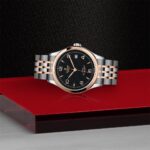 Elegant two-tone stainless steel and rose gold luxury watch with a black dial.