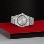 Tudor luxury watch displayed on red acrylic with a sophisticated black textured background.