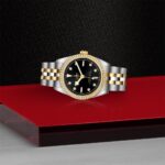 Elegant luxury watch with black dial and gold accents on a striking red background.
