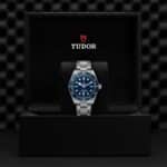 Elegant Tudor watch in luxurious presentation box with deep blue dial and stainless steel bracelet.