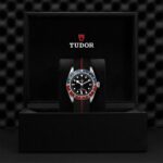 Luxurious Tudor watch in elegant presentation box with striking two-tone bezel and black textile strap.