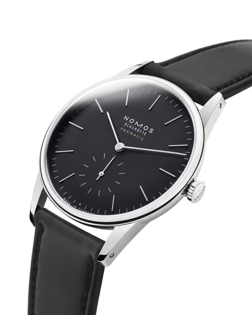 Elegant Nomos Glashütte watch with black dial and leather strap, showcasing minimalist luxury design.