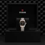 Luxurious Tudor watch in a sleek black box, showcasing exquisite craftsmanship and timeless design.