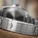 Close-up of a luxury wristwatch bracelet with polished stainless steel and elegant clasp design.